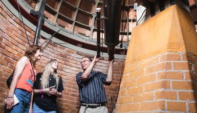 曼迪·莱布(右)和伊莎贝尔·亨森与博士交谈. 2023年“停止日”，David Clevette在Doane的Boswell天文台参观大楼. 